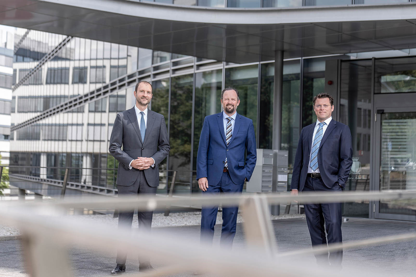 Erfahrenes Anwaltsteam der Kanzlei Winkler & Partner vor dem Firmensitz Bülowbogen Business Center Stuttgart ImageDrei Anwälte der Kanzlei Winkler & Partner in Stuttgart stehen vor dem modernen Bürogebäude Bülowbogen Business Center Stuttgart– professionelles Teamfoto für rechtliche Beratung in Deutschland.